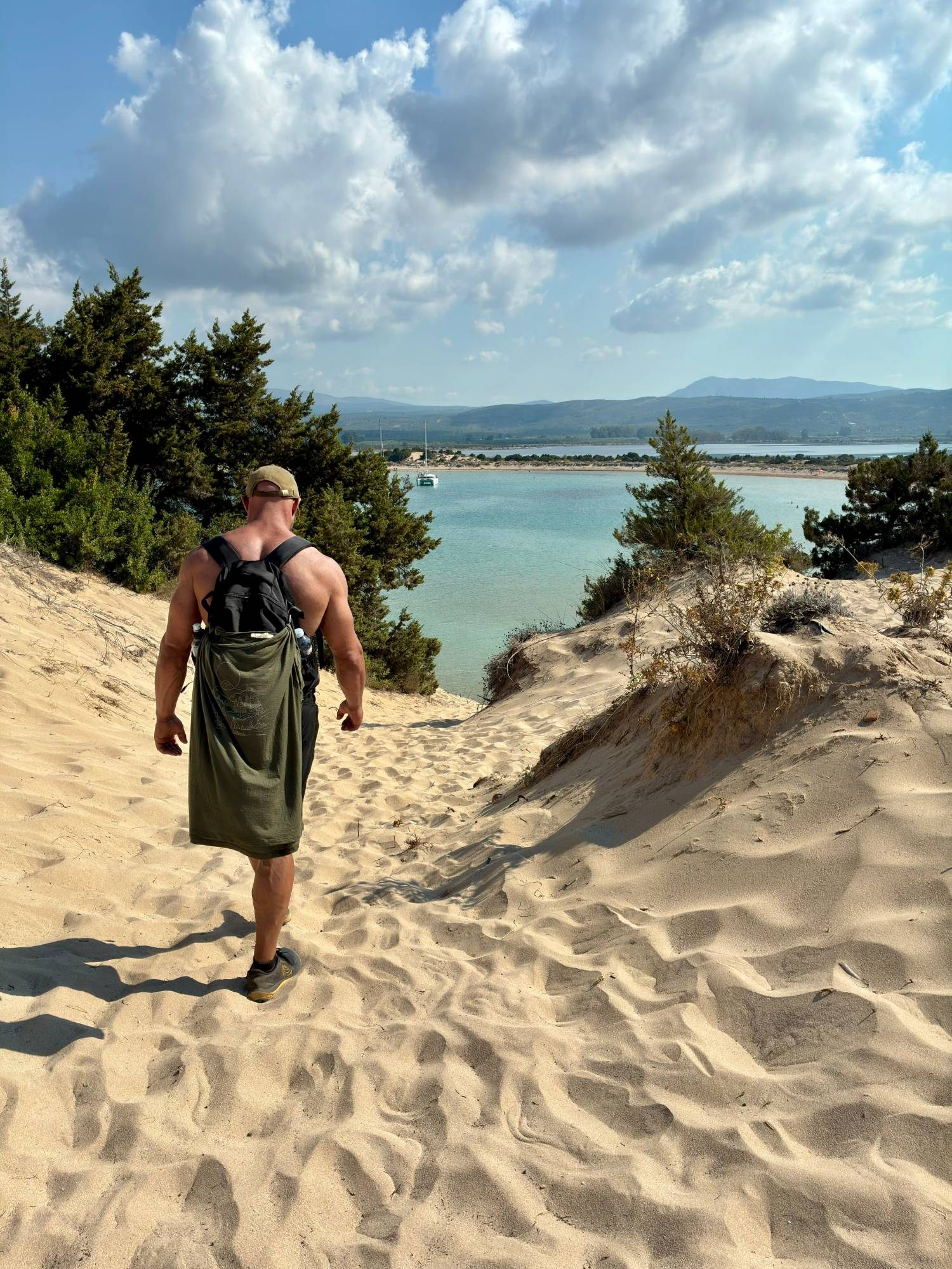 Walking down through the sand dunes towards the turquoise bay of Voidokilia, with Gialova Lagoon behind